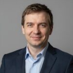 Портрет уверенного российского бизнесмена с дружелюбным взглядом на размытом нейтральном фоне в студии