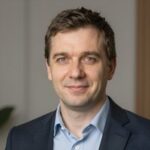 Портрет уверенного российского бизнесмена с дружелюбным взглядом на размытом нейтральном фоне в студии