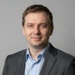 Профессиональный портрет уверенного российского бизнесмена на размытом нейтральном фоне для сайта Логан Клаб